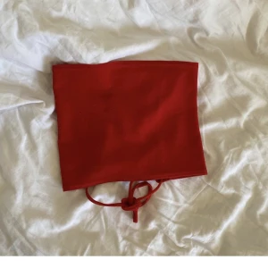 Fest topp - Röd fest topp med knytning i ryggen. Str S men passar Xs-M då den går att justera där bak!  Den andra bilden visar mer hur färgen ser ut på riktigt.