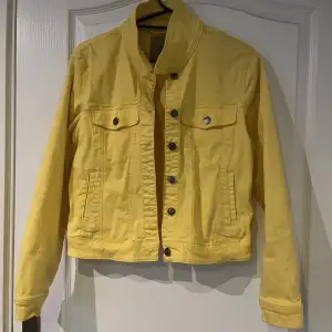 En gul jeansjacka köpt second hand använd endast en gång