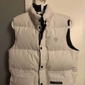 Canada Goose väst - En vit äldre modell av Canada Goose väst i storlek XS,  säljer då jag känner att det inte riktigt är min stil. Hör av er för bilder eller frågor 