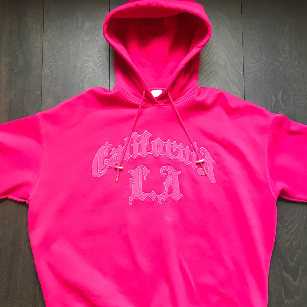 Oversized rosa hoodie med broderat tryck. Fleece-material på insidan och stor luva. Använd några gånger, bra skick :). Hoodies.