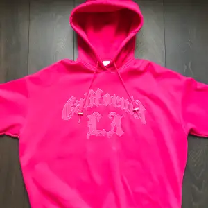 Oversized rosa hoodie med broderat tryck. Fleece-material på insidan och stor luva. Använd några gånger, bra skick :)