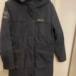 8848 vinterjacka  - Superskön vinterjacka från 8848 i mattblå färg. Teddyluva, två stora fickor fram, två bröstfickor att stoppa in och värma händerna i. Använd men i gott skick. Inte den allra varmaste men passar toppen ner till  några minus. Strl 36 men mer som en 38.