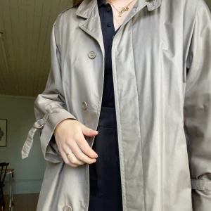Brun trenchcoat - Brun trenchcoat i storlek 38 från Junesco of Sweden Exclusive Coat, fodrad i 100% ull. Sparsamt använd i jättefint skick. Den är mer brun i verkligheten. Jag är 175cm lång. 