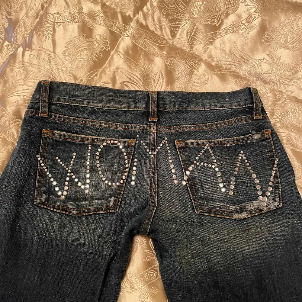 Jätte fina bootcut jeans som är vintage med rhinestones där bak som bildar ordet ”woman”  De är lite stora och långa på mig Står storlek 29 men jag brukar ha ca 34 så skulle säga att de passar 34/36 Midjemått 36 innerbenslängd 80 men man kan vika in de. Jeans & Byxor.