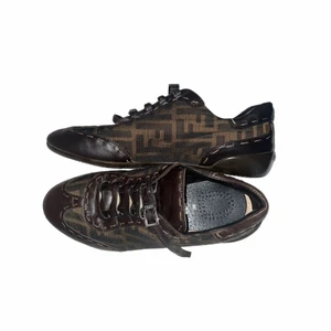 Fendi skor - sneakers med snörning har tillverkats av Fendi Zucca- canvas i en nyans av brunt och har matchande läderkanter, tyvärr fattas orginalsulan men nya lädersulor tillkommer obs: märkbart slitage på skosnörena. Jämförspris:  2 679kr, 2 400kr, 1000kr +frakt 