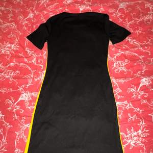 En klänning som är svart men med gul & vit rand