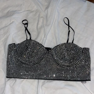 (Intressekoll) Bralette med stenar - Aldrig använd! Köpt på zara ett halvår sedan. Topp i svart med stenar, ofodrad bralette Säljer endast vid bra bud. Inga defekter alls! Storlek L men mer som M