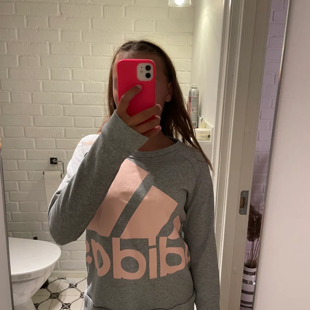 En grå adidas hoddie med rosa tryck. Hoodies.