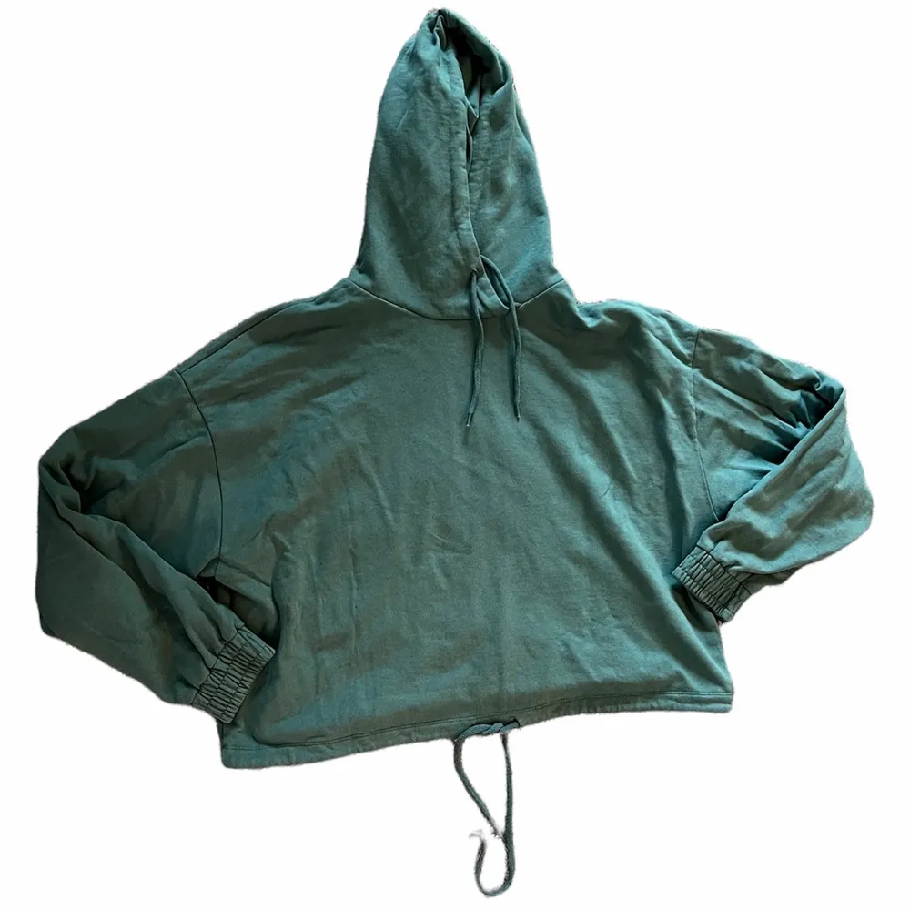Croppad hoodie med snören så att man kan dra åt den i midjan. Fint skick! Färgen är svår att fånga på bild men skulle säga att den är dovt turkos. 🦋. Hoodies.