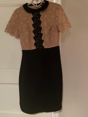 Vacker klänning - Svart och gammalrosa klänning i stl 36. Totallängd 96 cm. Liten dragkedja bak, ganska snäv modell med spets på övre delen. Använd 1 gång, blev sedan för liten för mig. Nyskick