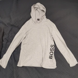 Hugo Boss Hoodie - Detta är en Hugo Boss hoodie (munkjacka). Storlek "L". Det är en skön och tunn hoodie som passar bra på sommaren för den luftar bra. Denna hoodie är bara använd 2-3 gånger. 