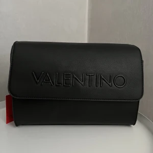 Valentino väska  - Helt oanvänd axelremsväska från Valentino. Superfin och kan användas både till vardags och speciella tillfällen. Tyvärr har väskan inte kommit till användning och därav säljer jag den.❤️Köpt för 1500kr på Zalando men säljer nu för 800kr + frakt😍