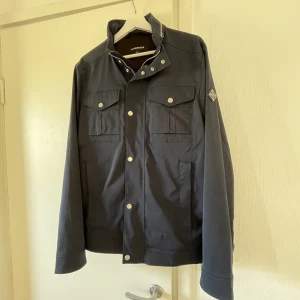 J.Lindberg bailey field jacket (navy) - Field jacka från J.Lindberg i toppenskick. Köpt för någon månad sedan till nypris (3500kr) men blev endast använd 2/3 gånger! Skick 10/10 och den inte var aldrig använd i regn. Hör av dig vid intresse eller om du vill ha fler bilder. Fri frakt! 😄