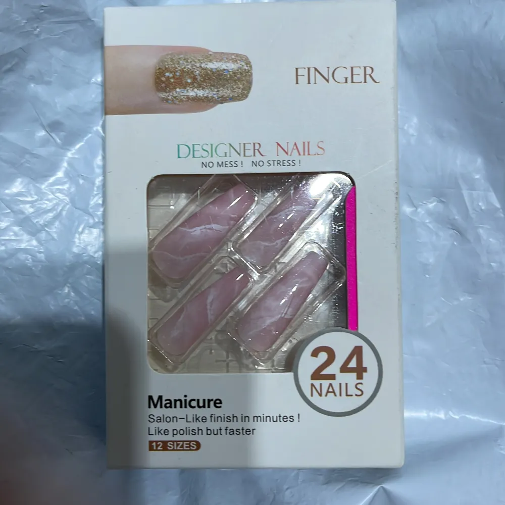 Oöppnat packet av rosa press on naglar med marmor mönster.. Accessoarer.