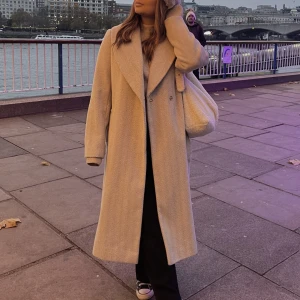 LÄNGRE KAPPA M BÄLTE - En lite längre kappa som har ett skärp i midjan. Har tyvärr inte kommit till användning, så endast använd en gång.   Sista bilden ger mer rättvisa på färgen i dagsljus. Fin kall beige. MAGISKT tyg!   I Strl 46, är vanligtvis en 36/S men önskade oversized.