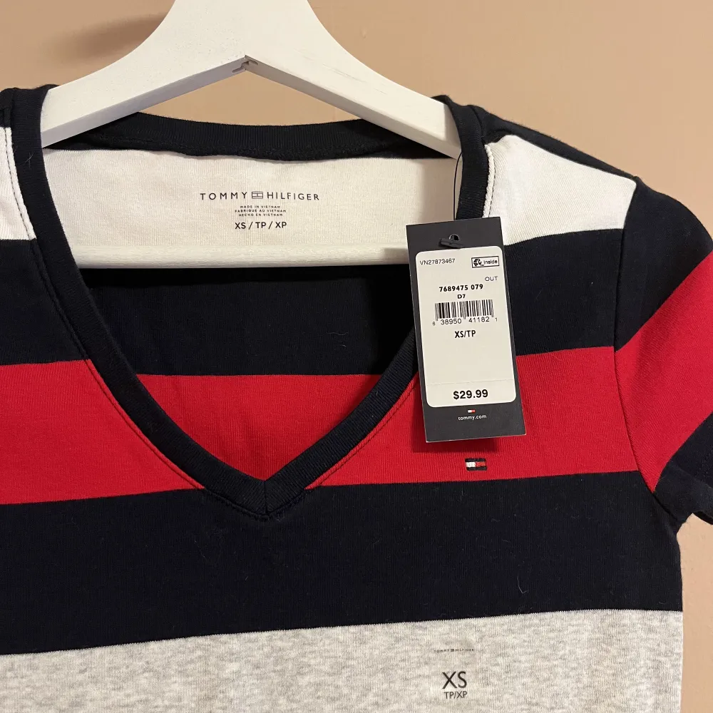 En Tommy Hilfiger T-shirt i storlek XS, helt ny med prislappen på! Nypris 320 kr, säljer för 200 kr! . T-shirts.