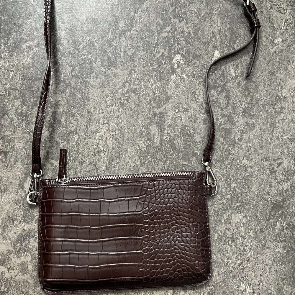 Väska med avtagbart band   Färg: brun med lite vintött inslag. Väskor.