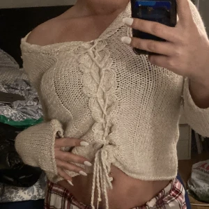 Stickad Tröja - En stickad tröja som inte kommit till någon användning. Den går att göra större och mindre genom att dra i snörena där fram.