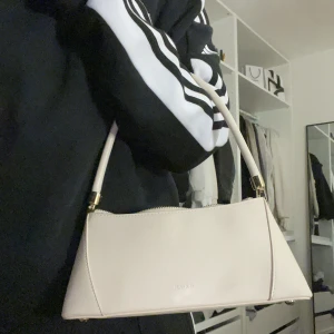 Handväska från nakd  - Min fina beiga Handväska från nakd som är slutsåld , den har guldiga detaljer och är en fin beige ton, använder inte längre och därför vill sälja , kan diskutera om priset 