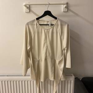 Fin blus i en vit-beige strl 38. En fin blus med knytning 