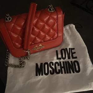 skitsnygg röd väska från moschino!! väskan är använd men ändå i fint skick! säljer den för den inte längre kommer till användning!!