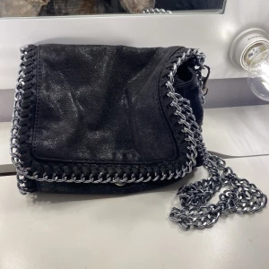 Handväska  - Knappen på handväskan är sönder men väskan har även en dragkedja man kan stänga med så inget problem alls. 