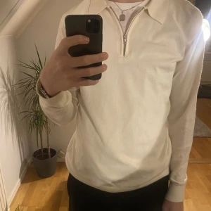 Tunn Gräddvit Polotröja - Säljer min snygga nästintill oanvända tunna tröja med polokrage och dragkedja. Gräddvit färg. 