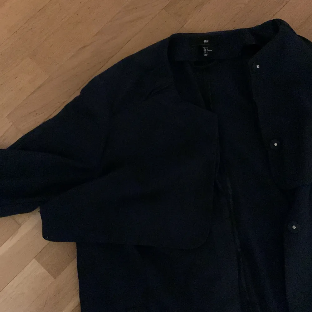 Lång mörkblå trench coat, använts under en säsong, fortfarande i mycket gott skick. Elegant och stilren för en minimalistisk look. Har fickor . Jackor.