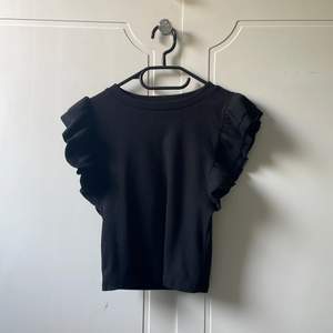 En svart tröja från Sara med volangarmar 