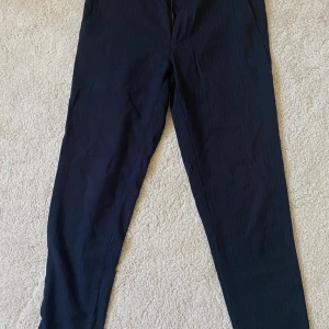 Lindbergh kostymbyxor  - Ett par marinblå kostymbyxor med små vita streck längs med byxan. Knappt använda 