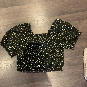 Topp - Fin blommig topp, mycke finare på. Man kan ha axelbanden över axlarna eller nere på armarna