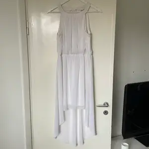Vit klänning från Vero Moda, klänningens tyg är längre bak och den har knytning i ryggen 
