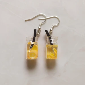 Örhängen - Fruktdrink Citrus - Nya oanvända nickelsäkra örhängen. Berlock med glasbehållare. Handgjorda i Sverige. Höjd ca 20mm. Levereras i förseglad förpackning.