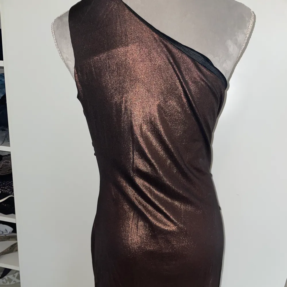 En brun/glittrig klänning som är väldigt fin! Aldrig fått chans att använda den därför säljs den!💓 fin knytning där fram!! Hur fin som helst den är från AX Paris. Klänningar.