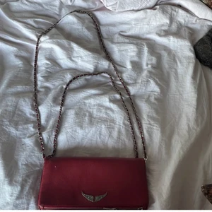 Röd Zadig väska - Hej, säljer nu denna Zadig väskan då jag inte får någon användning för den längre! Köpte den september 2021 och den är ganska använd men inte något man ser på den. Säljer inte under 1100kr! 💘 det är den stora modellen. 