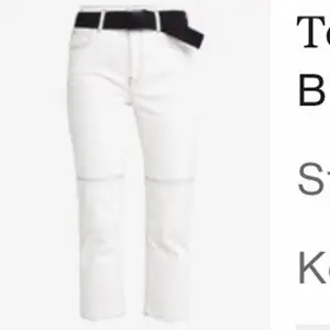 Supersnygga croppade vita jeans med svarta sömmar från Topshop. Tillhörande bälte i midjan. Strl W28/L30.