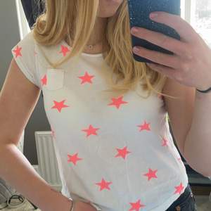Vit t-shirt med neon-rosa stjärnor från H&M. Storlek 146/152. Säljer för 20kr +frakt ☺️☺️