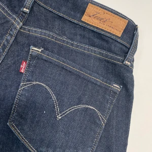 Levis Demi Curve stl 25/32 i nyskick  - Mörkblå Levis i nyskick. Storlek 25/32. Smala nertill. 