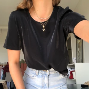 T-shirt - Glansig t-shirt köpt på Nelly strl xs. Säljer pga aldrig fått användning för den därav i nyskick❣️