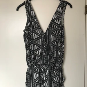 Ginatricot mönstrad jumpsuit stl S - Säljer denna mönstrade jumpsuit med snörning i storlek S! Den passar mig tyvärr inte alls och därför säljer jag den! Fungerar perfekt för sommaren!