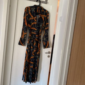 Långärmad skjortklänning - Skjortklänning med mönster från Soaked in luxury. Använd 2 ggr. Jättebekväm på. Klänningen går ner till anklarna. 100% viskos.