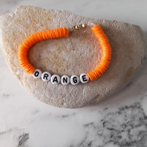 Armband där det står orange  - Dett armband är gjort på clay pearls + frakt och DU står för frakten!❤ 