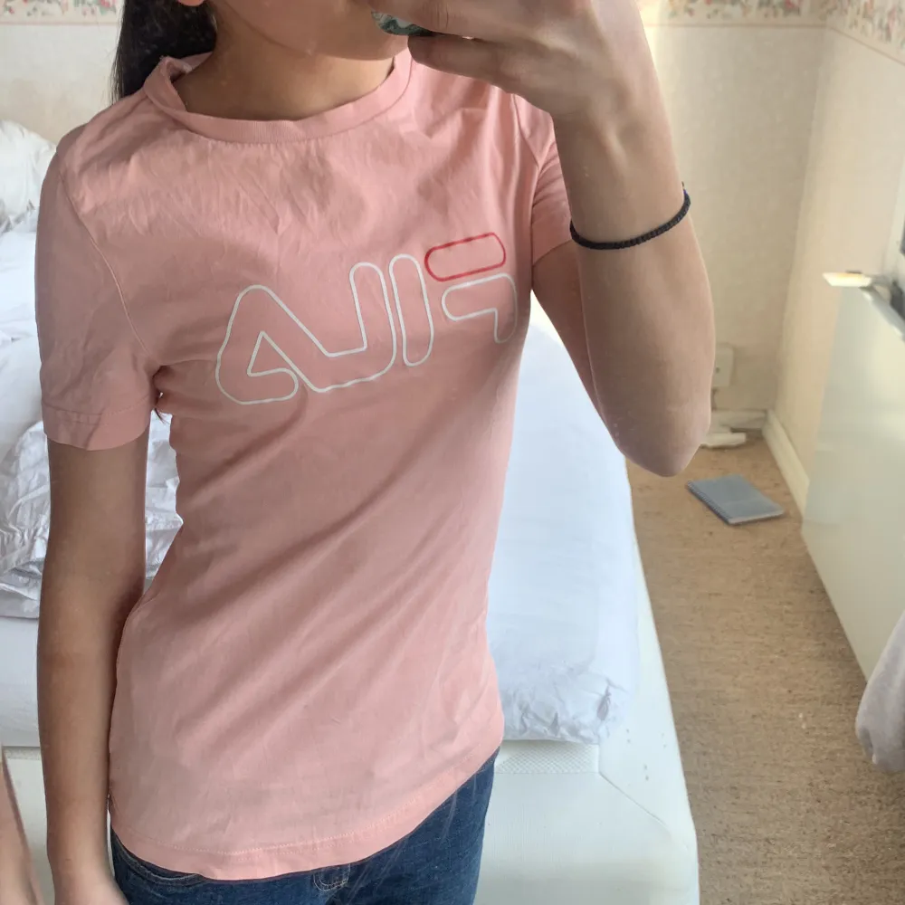 En jättefin fila t-shirt som är rosa fila texten är vit med en liten röd detalj! Säljer för att den inte riktigt är min stil! Men jättefin ändå❤️. T-shirts.