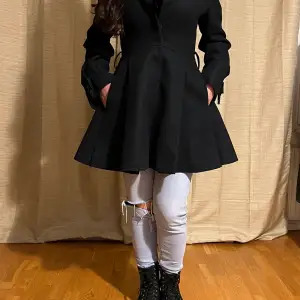 Ny knälång svart kappa i ull med sammetsslag och avtagbart skärp. Ord pris 9000 kr. Inga slitningar. Inga märken eller fel.