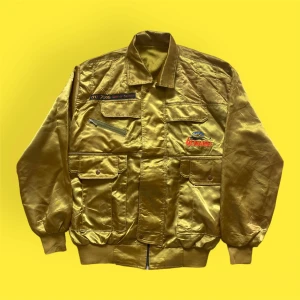 Vintage Retro Bomber Jacka - En fin glansig jacka i fint skick. Vintage och kan användas ut och in. Märket är Villa ”King of Jacket”. Färgen är guldgrön. Tyvärr ingen lapp i, uppskattar storlek som M. För fler bilder eller mått kontakta mig!!! 💫