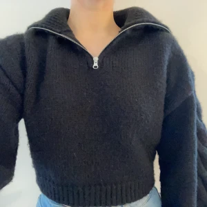 Stickad tröja - Säljer denna stickade tröja med halv dragkedja och stor krage. Tröjan är från NA-KD och är något kortare i längden. Måttligt använd och lite nopprig, men syns inte särskilt tydligt på. 