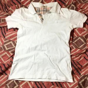 Burberry piket ifrån 80tal - Väldigt fin vit burberry piket ifrån 80tal. Inga större skador förutom en liten fläck på insidan av kragen fast det märks inte kan diskutera priset tveka inte att kontakta om Ni har några frågor 