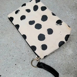 Sminnkväska pri kig - Sminkväska/ liten necesär beigegul m svarta prickar. Dragkedja och extra utvändigt fack. Svaart plast på insidan. Ca 21×13 cm.