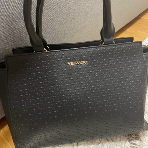 Vezzano väska  - Svart lagom stor väska. Märket är Vezzano, köpt för 500 kr men säljs för 350 kr eller i värsta fall under 350. Använd max 4 ggr och väljer därför att sälja den.