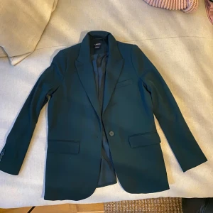 Kappahl kavaj - Helt ny oanvänd Kappahl kavaj. Kostade 799kr säljer den för 250kr. Mörkgrön.
